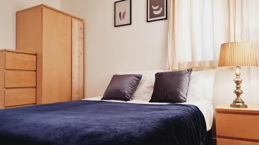 a bedroom with a bed with a blue blanket and a lamp at Fabulous one bedroom Apartment Sheffield City Centre in Sheffield