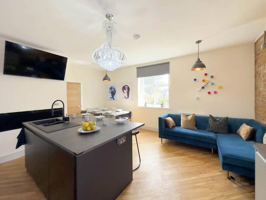a kitchen and living room with a blue couch at The Yorkshire Hosts - Knights Stay 