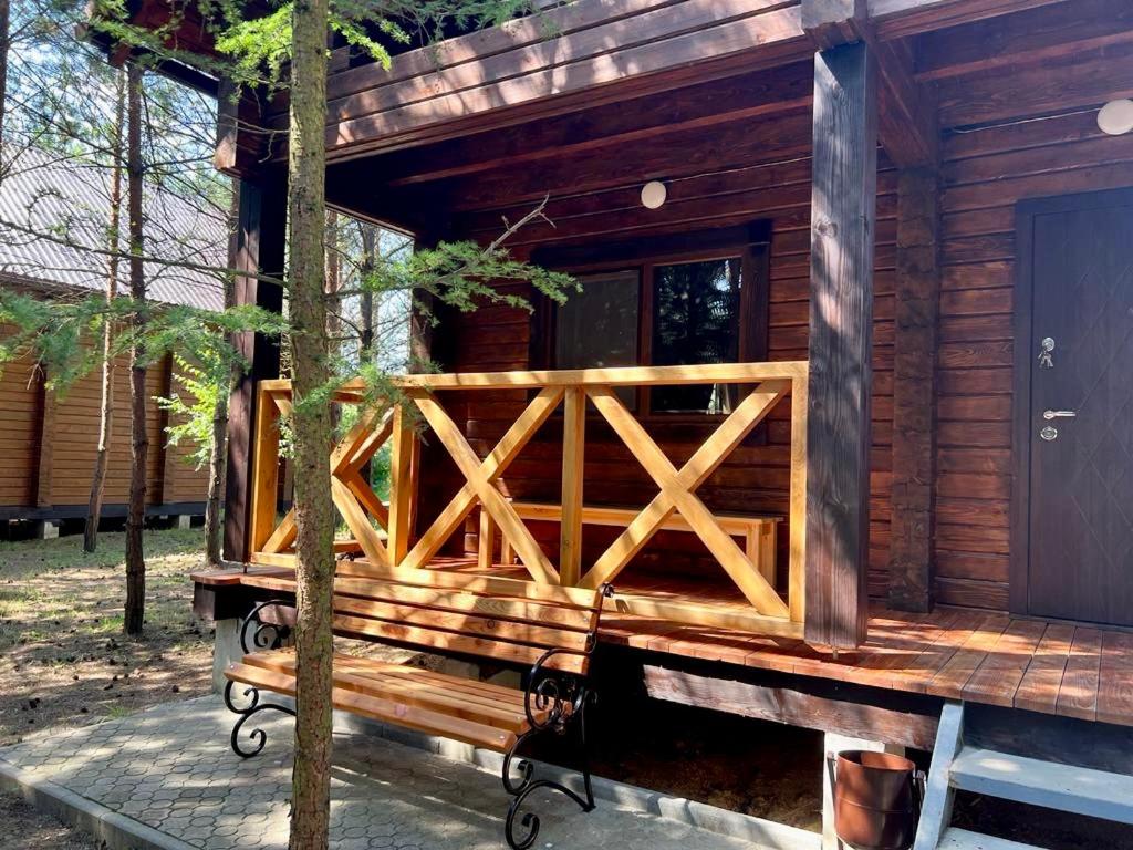 a wooden cabin with a bench in front of it at Family Resort in Mostiska