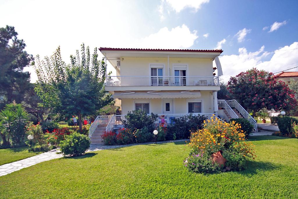 a large house with a lawn in front of it at Anna -House Maria Manolaki, 2-Βedrm Apartment in Vourvourou