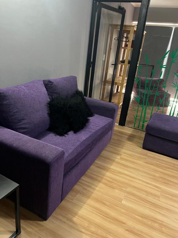 un sofá púrpura en una sala de estar en Alto Nqn en Neuquén