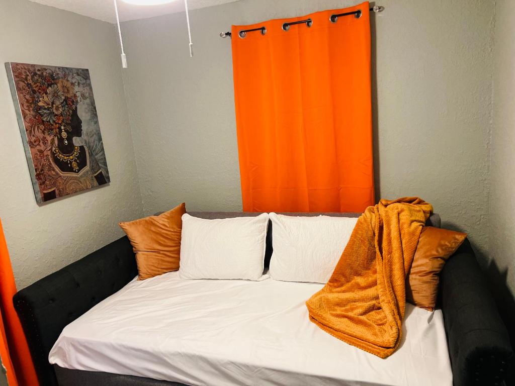 sypialnia z pomarańczową zasłoną i łóżkiem w obiekcie 3bdrm Fruit Tree Home near downtown Orlando w Orlando