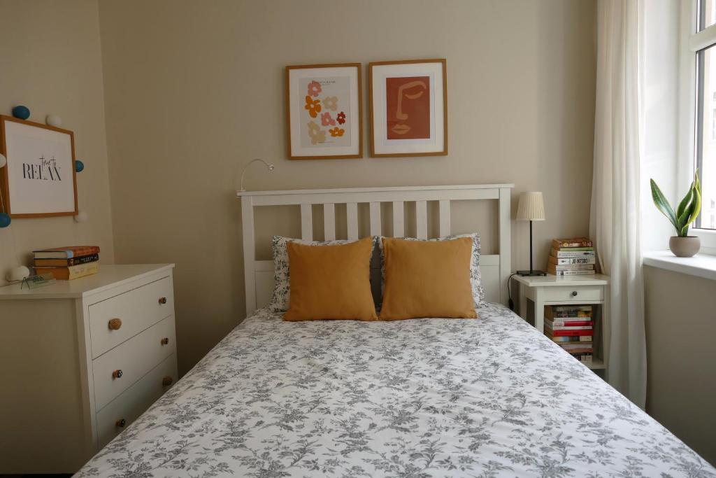 グダニスクにあるFeel at home - Old Townのベッドルーム1室(オレンジ色の枕が付いたベッド1台付)