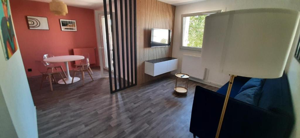ein Wohnzimmer mit einem Sofa, einem Tisch und einem Fenster in der Unterkunft La Terra-cotta - 1 à 4 personnes in Lieusaint