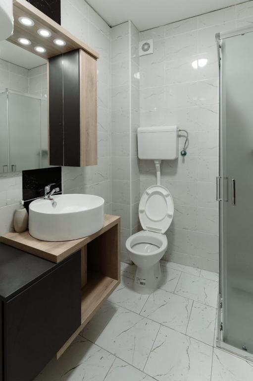 un bagno con wc, lavandino e doccia di Apartman Resident a Sombor