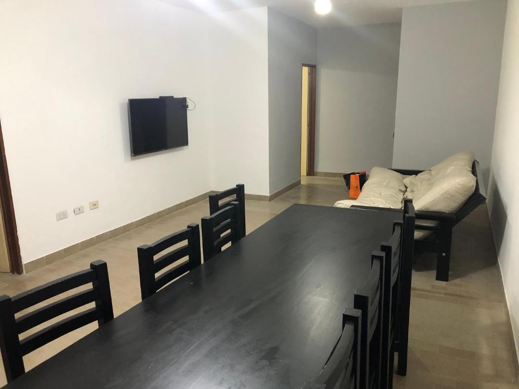a room with a table and a couch and a tv at Departamento 4 dormitorio in Corrientes