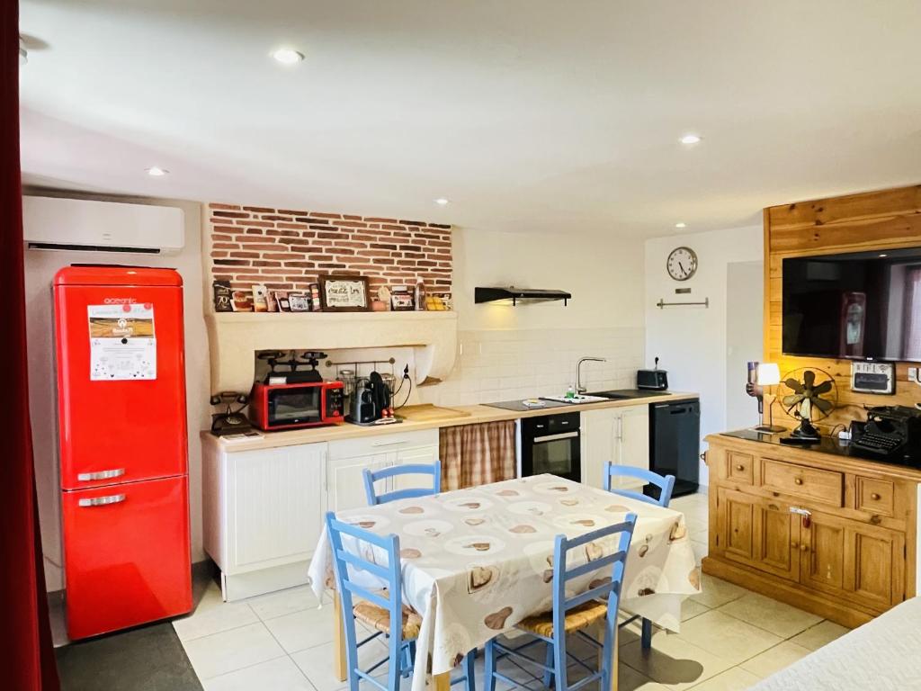 a kitchen with a table and a red refrigerator at Gite du Moulin in Saint-Laurent-dʼAndenay