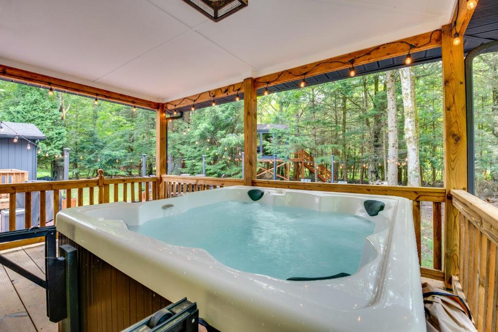 eine große Badewanne auf einer Terrasse mit Bäumen in der Unterkunft Hot Tub, Beach Access Albrightsville Retreat! in Albrightsville