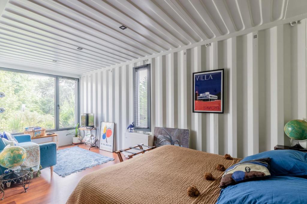 a bedroom with a bed and a large window at La Villa Joséphine in Écully