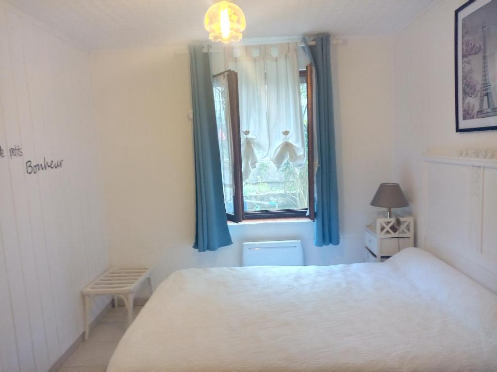 sypialnia z białym łóżkiem i oknem w obiekcie Villa Arc en Ciel et clé des champs w mieście Contrexéville