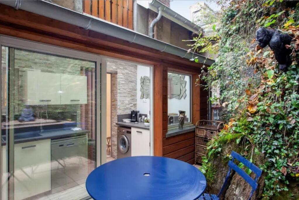 une cuisine extérieure avec une table bleue et une terrasse dans l'établissement Face aux Thermes: lit double, terrasse, wifi, à Saint-Martin-dʼUriage