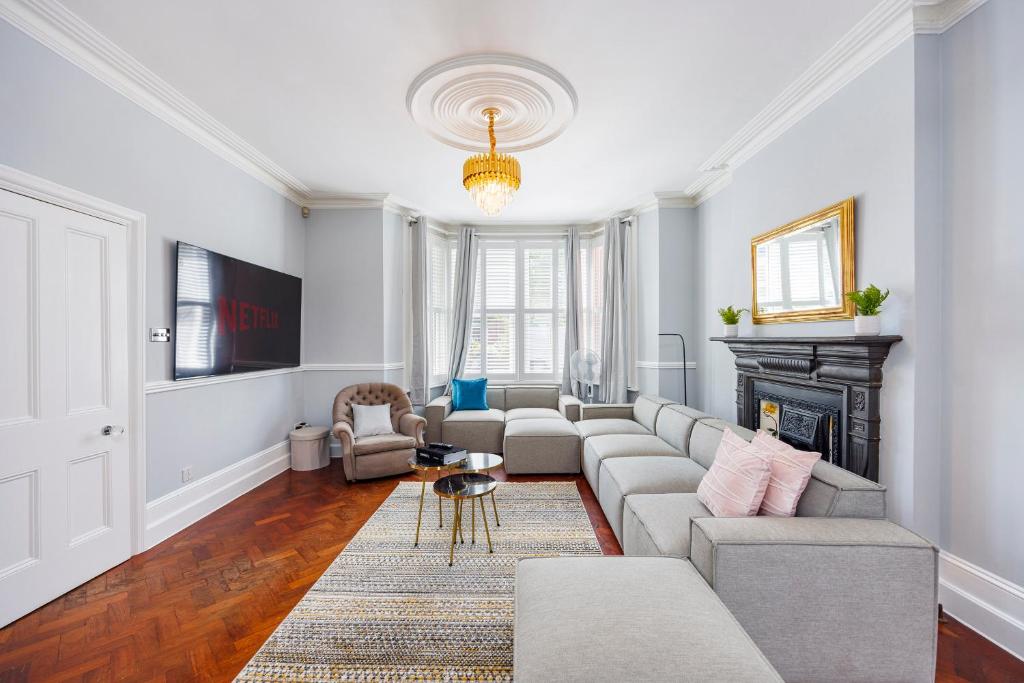 uma sala de estar com um sofá e uma lareira em 6 Bedroom House by AV Stays Acton Sleeps 11 Free Parking em Londres