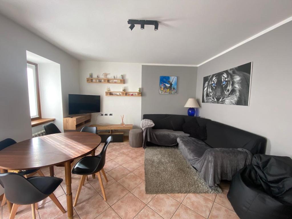 a living room with a black couch and a table at Appartamento Ari in Vermiglio