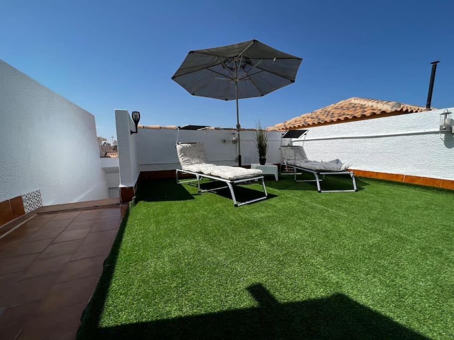a patio with two chairs and an umbrella at Great Sun Terrace Close to Beach in Gran Alacant