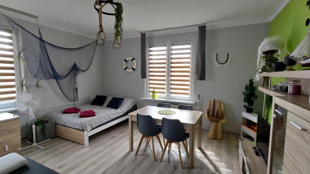 een kleine kamer met een bed en een tafel en stoelen bij Stylowy apartament w Gdyni z bezpłatnym parkingiem i niedaleko plaży in Gdynia
