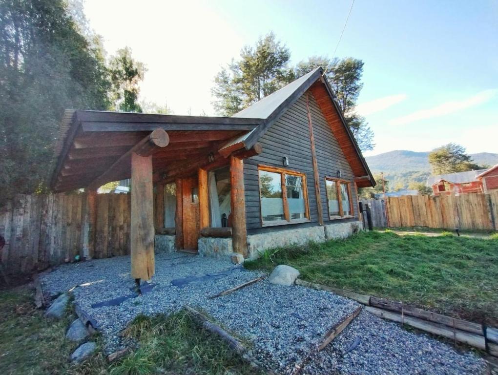 una pequeña casa con techo de madera en un patio en 4 Vientos, en Villa La Angostura
