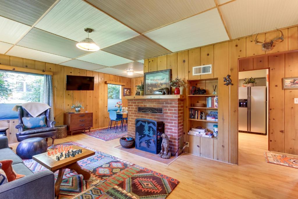 uma sala de estar com lareira e paredes de madeira em Vintage Cottage by Leaburg Canal with Large Yard! em Vida