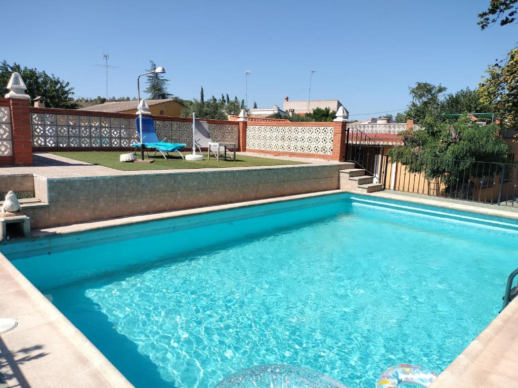 una piscina con agua azul en un patio trasero en Villa les palmiers, en Rafelguaraf