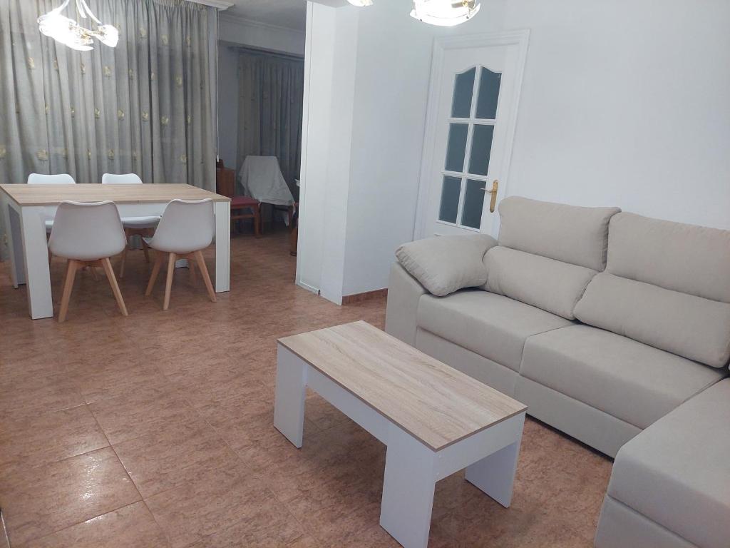 ein Wohnzimmer mit einem Sofa und einem Tisch in der Unterkunft APARTAMENTO ESTACION a 3 min in Córdoba