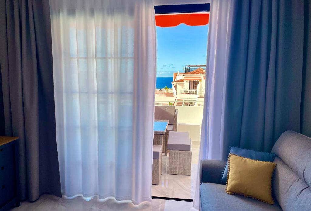 ein Wohnzimmer mit einem Fenster mit Meerblick in der Unterkunft Luxury Diamond - Ocean view, Big terraces, Air Con, Wifi in Los Cristianos