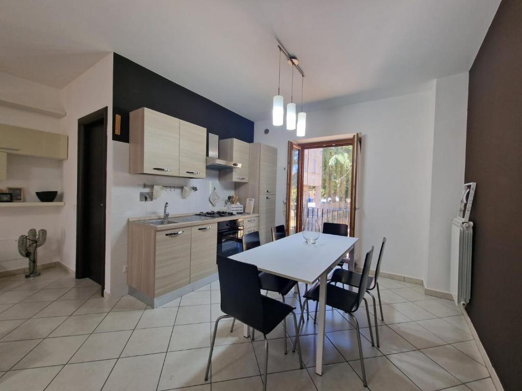 a kitchen with a white table and chairs and a table and a counter at CASA.AD in Bracciano