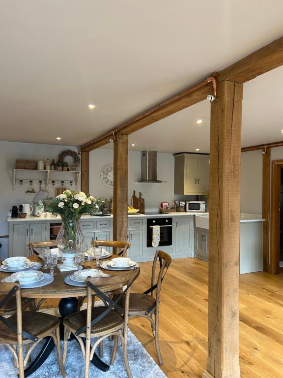 a kitchen and dining room with a table and chairs at Hideaway Barn Coltishall in Coltishall