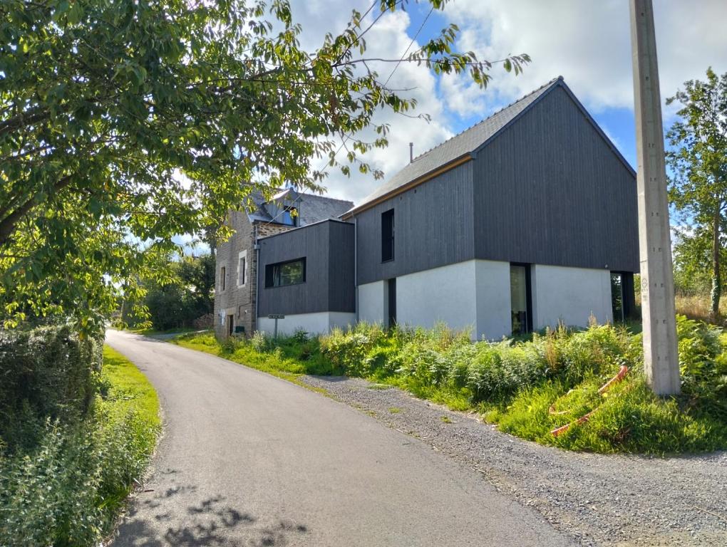 a black and white building on the side of a road at Chez Clo & Tonio in Saint-Hélen