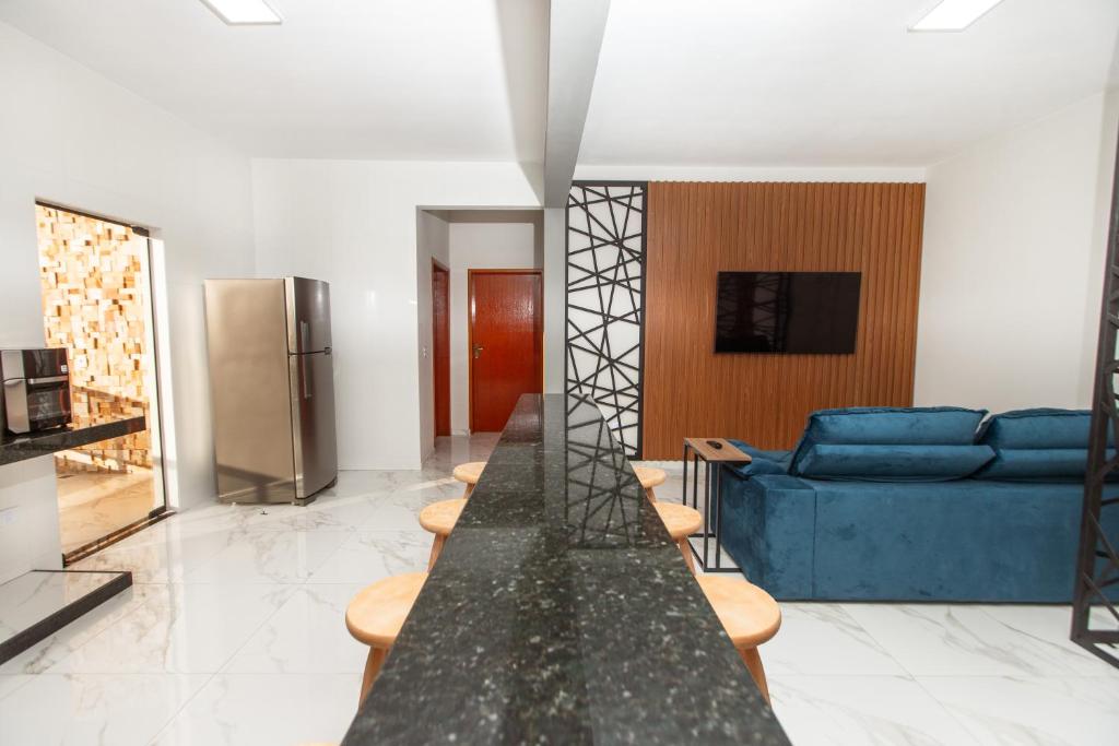 a living room with a blue couch and a table at ECOLETRAS APART - HOTEL - SÃO THOMÉ DAS LETRAS Mg in São Thomé das Letras