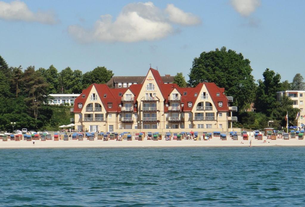 a large building on a beach next to the water at Strandhotel Grömitz in Grömitz