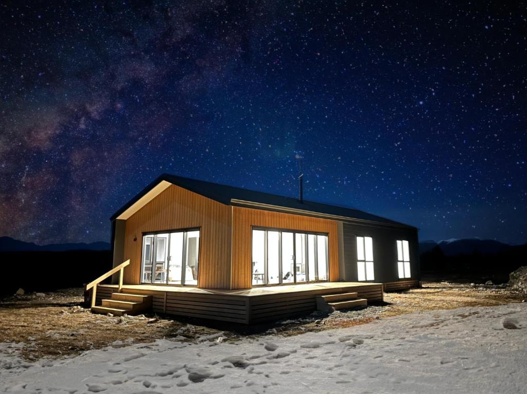 een kleine hut in de sneeuw onder een sterrenhemel bij Manuka Vista in Twizel