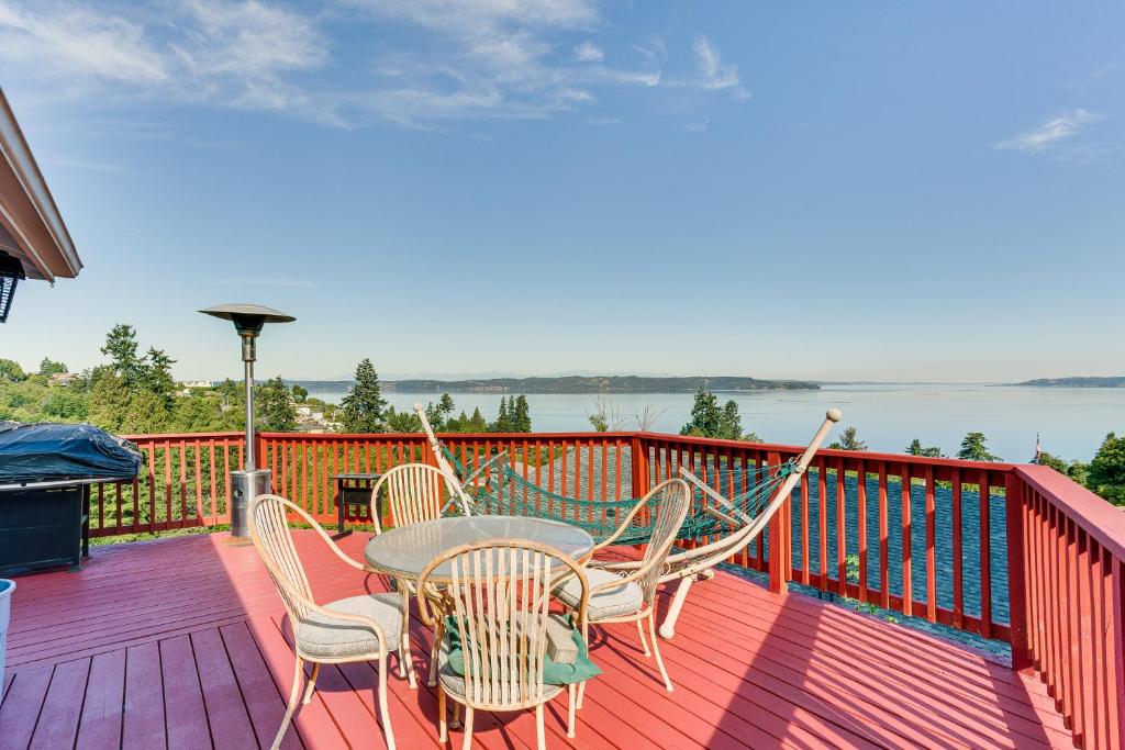 フェデラルウェイにあるFederal Way Vacation Rental Bay and Mountain Views!のテーブルと椅子が備わるデッキから水辺の景色を望めます。