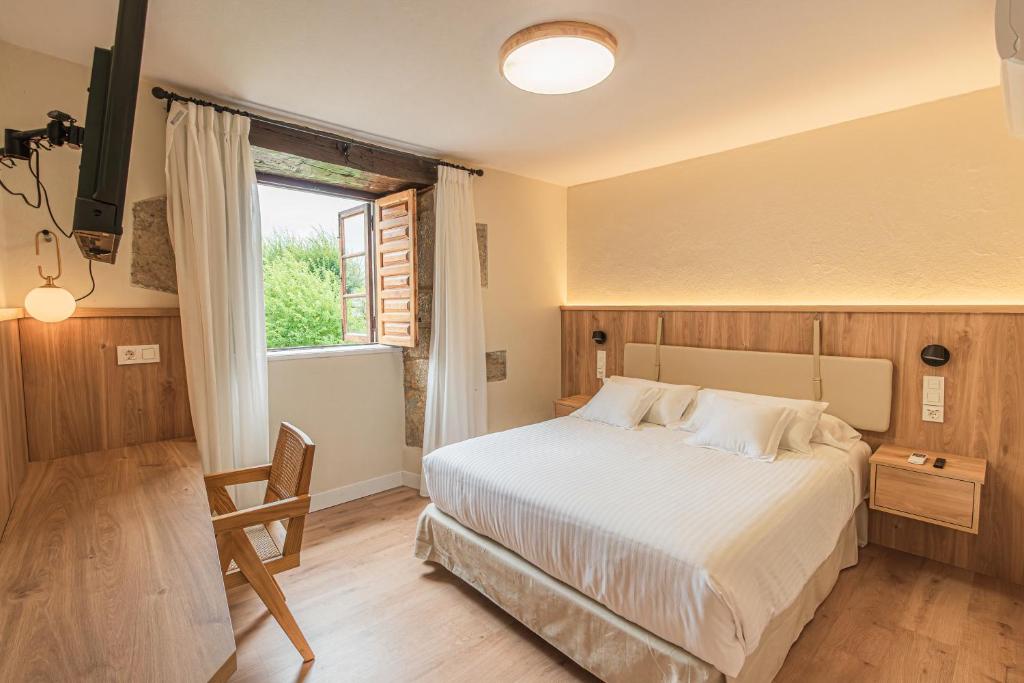 - une chambre avec un grand lit et une fenêtre dans l'établissement Hotel BESTPRICE Santillana, à Santillana del Mar