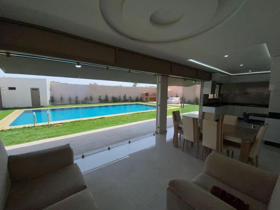 Villa avec piscine à Agadir في أغادير: غرفة معيشة مطلة على مسبح