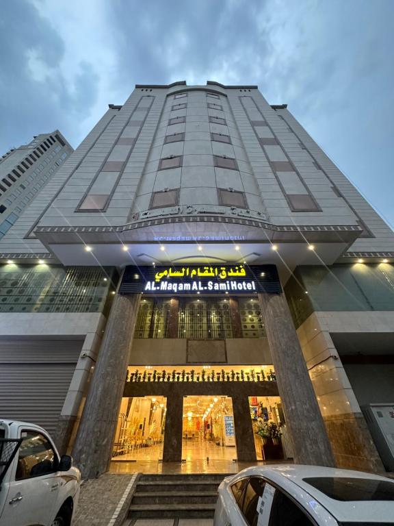 فندق المقام السامي للغرف والشقق المفروشة في مكة المكرمة: مبنى طويل وبه سيارات متوقفة أمامه