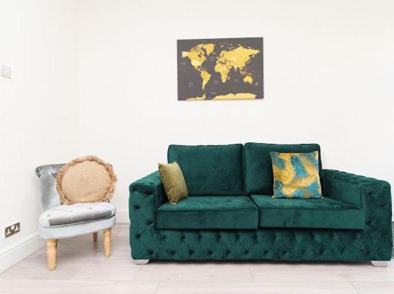 a living room with a green couch and a chair at The Victoria - Close to Centre - Sleeps 8 in Leeds
