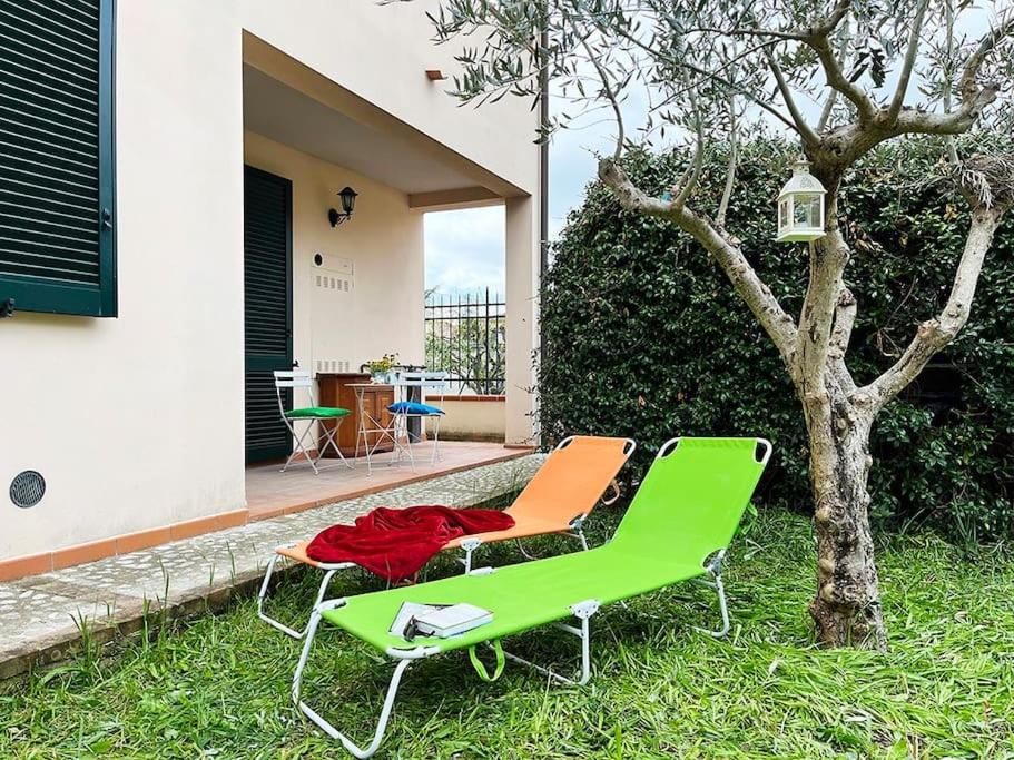 eine grüne und orangefarbene Bank neben einem Baum in der Unterkunft Gli ulivi di Mafalda - Garden * Parking * City centre in Spello