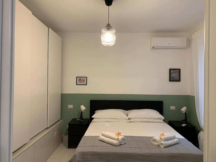 1 dormitorio con 1 cama con toallas en "CITY CENTER 10Stars"- Casetta Matteotti- Feel like HOME en Civitavecchia