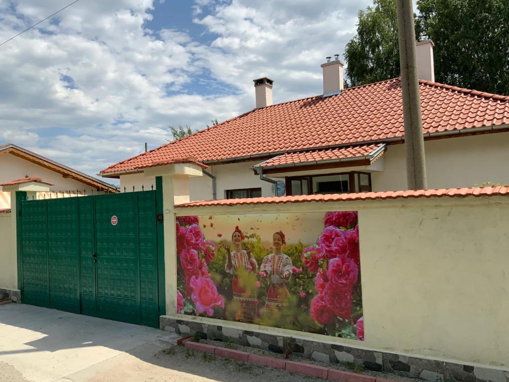 uma pintura ao lado de uma cerca em frente a uma casa em Къщи за гости Армагански път em Kazanluk