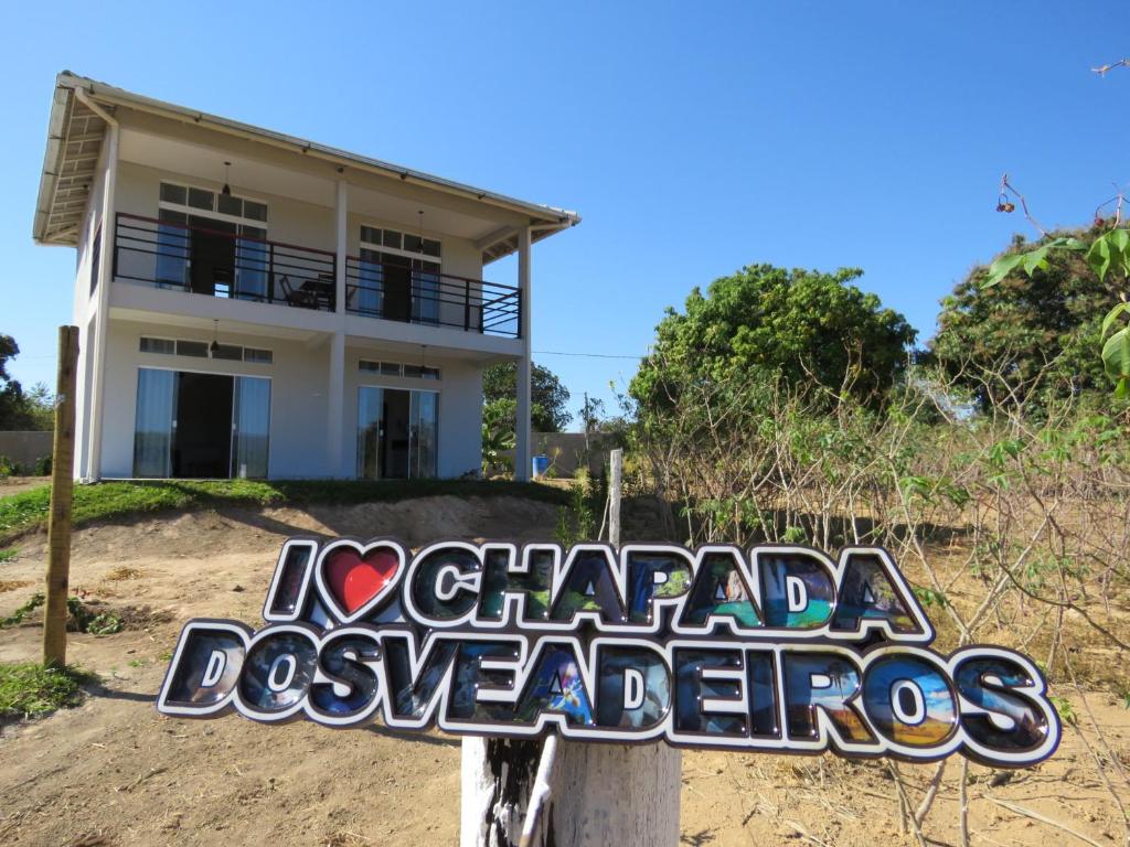 a house with a sign in front of it at Chácara Reserva do Cerrado in Cavalcante