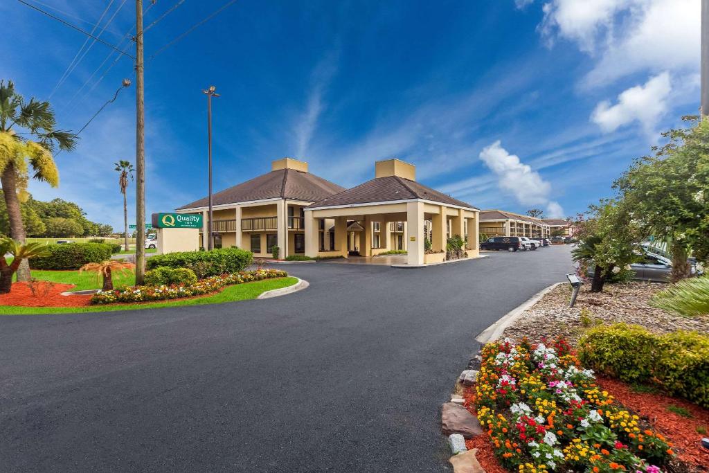 a road in front of a building with flowers at Quality Inn Coliseum in Charleston