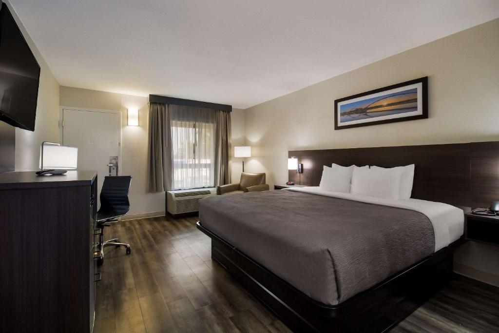 ein Hotelzimmer mit einem Bett und einem Fernseher in der Unterkunft Quality Inn Coliseum in Charleston