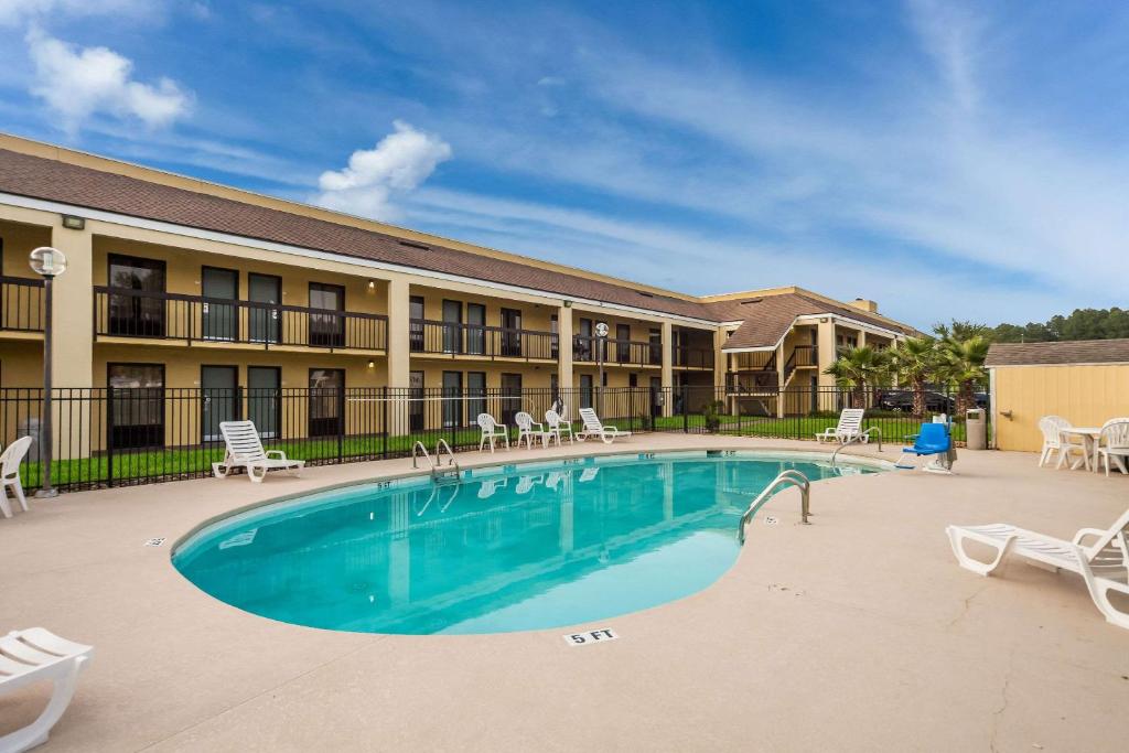 einen Pool in einem Resort mit Stühlen und einem Gebäude in der Unterkunft Quality Inn Coliseum in Charleston