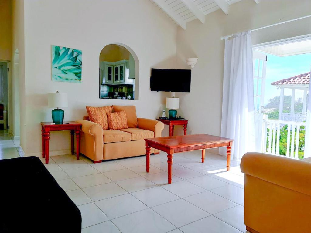 una sala de estar con un sofá y una mesa en Beautiful Seaside 2BR Apartments, en Christ Church