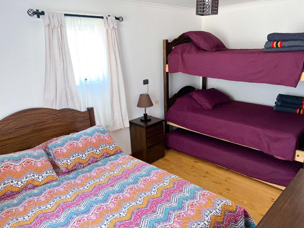 a bedroom with two bunk beds with purple sheets at Casa En El Tabo Magnolia in El Tabo