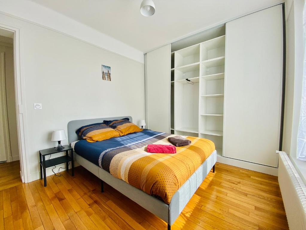 1 dormitorio con 1 cama con sábanas de color naranja y azul en Cozy Appart'3 - Centre ville & Proche Gare - Cozy Houses, en Massy