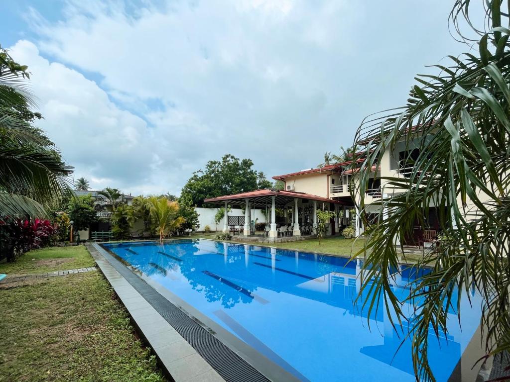een groot zwembad voor een huis bij Riverside Cabanas in Mirissa