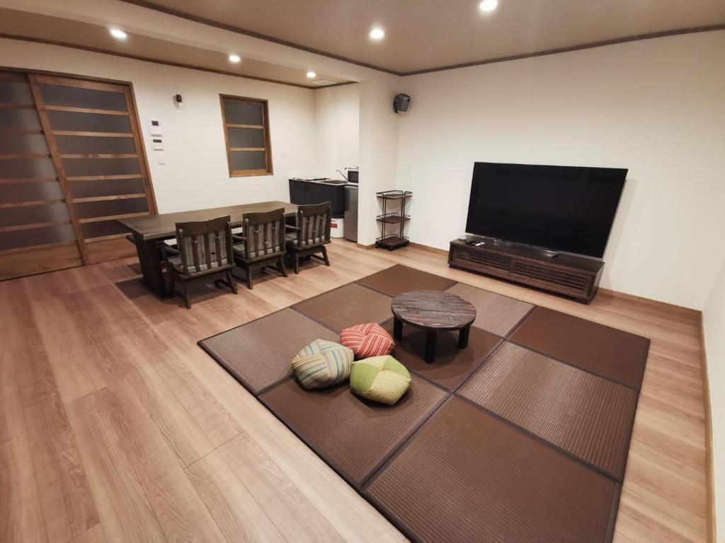 a living room with a television and a table and chairs at Hida Takayamasan no machi House - Vacation STAY 98088v in Takayama