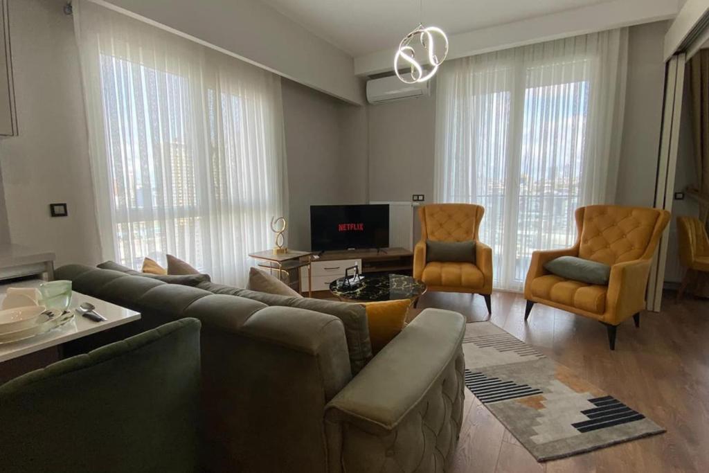 a living room with a couch and chairs and a tv at Toya next in Istanbul