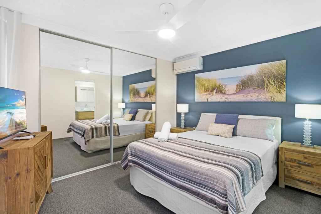 a bedroom with two beds and a flat screen tv at Oceanside Cove in Gold Coast