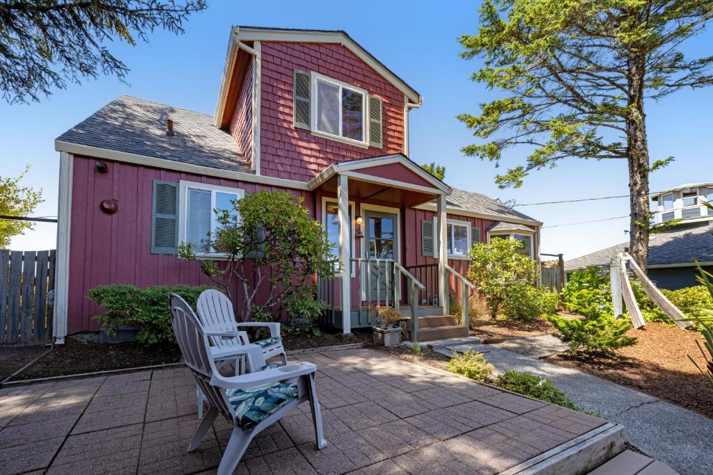 a pink house with two chairs on a patio at Whale Vista in Depoe Bay